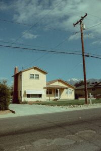 Two-storey family home with fresh exterior paint and mountains behind it